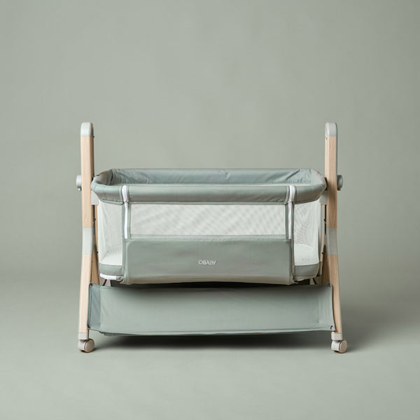 OBaby Cloud Bedside Crib Bundle Including Fitted Sheets – Sage with green bedding and wooden frame.