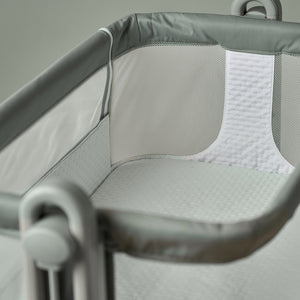 OBaby Cloud Bedside Crib Bundle Including Fitted Sheets – Sage interior with mesh sides and soft bedding.