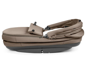 Beige fabric-lined baby bassinet with black plastic base and zippers in peg perego city loop pro 3 in 1 elite travel system pine bark