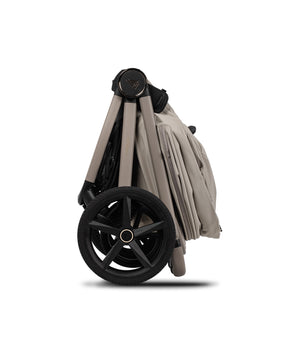 Beige and black venicci upline 3 travel system foldable stroller with sturdy frame and large wheels in pebble color