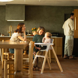 White wooden Nuna BRYN highchair with modern minimalist design and padded seat for comfortable baby seating