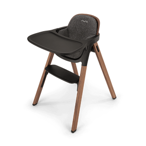 Modern nuna bryn highchair with wooden legs dark gray textured fabric seat and black plastic tray with brand logo