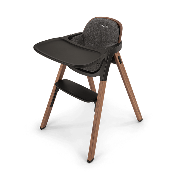 Modern nuna bryn highchair with wooden legs dark gray fabric seat and black tray for toddler dining use
