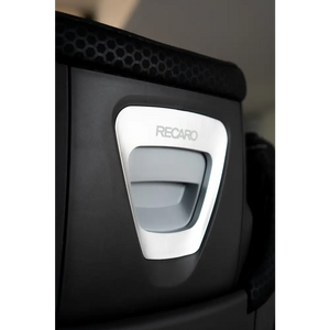 Close-up of the recessed grey handle on the rear of the AXION 1 headrest, surrounded by silver trim.
