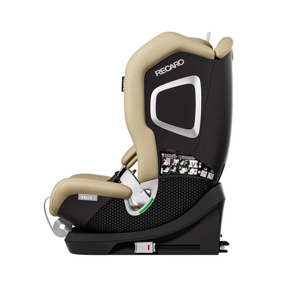 Recaro VELIX 1 in Elegant Beige, side view showing silver-trimmed shell, black base and coiled adjustment strap.