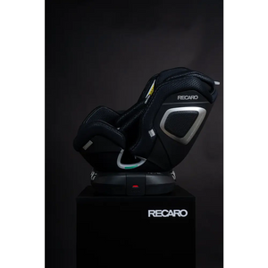 Recaro XENON 1 in Fresh Black, reclined side view on a black Recaro display pedestal.