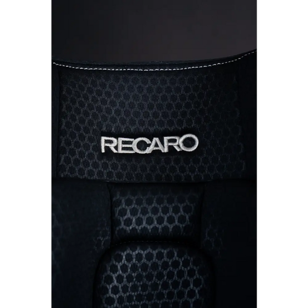 Close-up of the white Recaro logo embroidered on Fresh Black honeycomb-patterned upholstery.