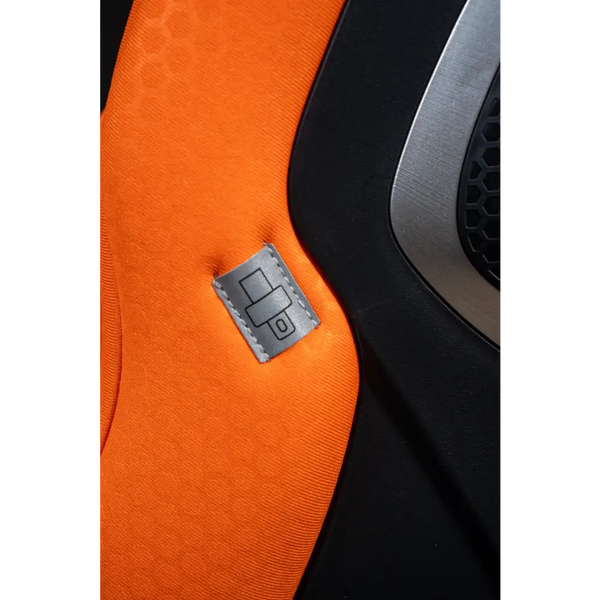 Close-up of orange XENON 1 upholstery with a grey stitched label showing a seat belt symbol.