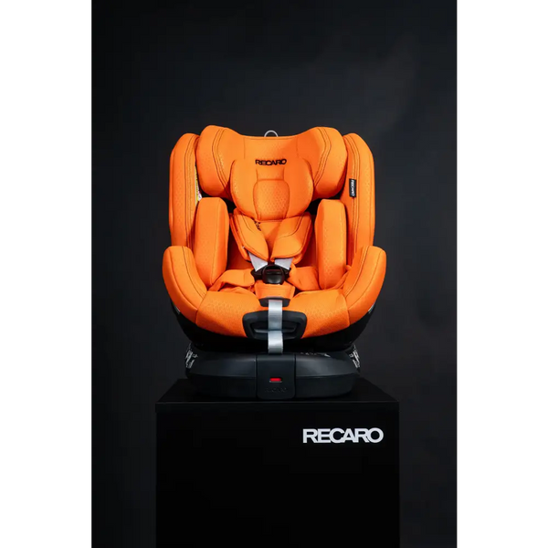 Recaro XENON 1 in Vibrant Orange, front view on a black Recaro display pedestal.