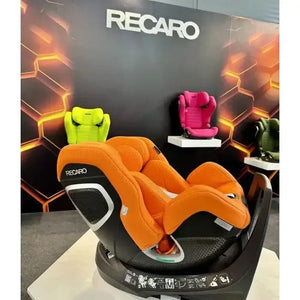 Vibrant Orange Recaro XENON reclined on a showroom display, with other colourful Recaro seats behind it.